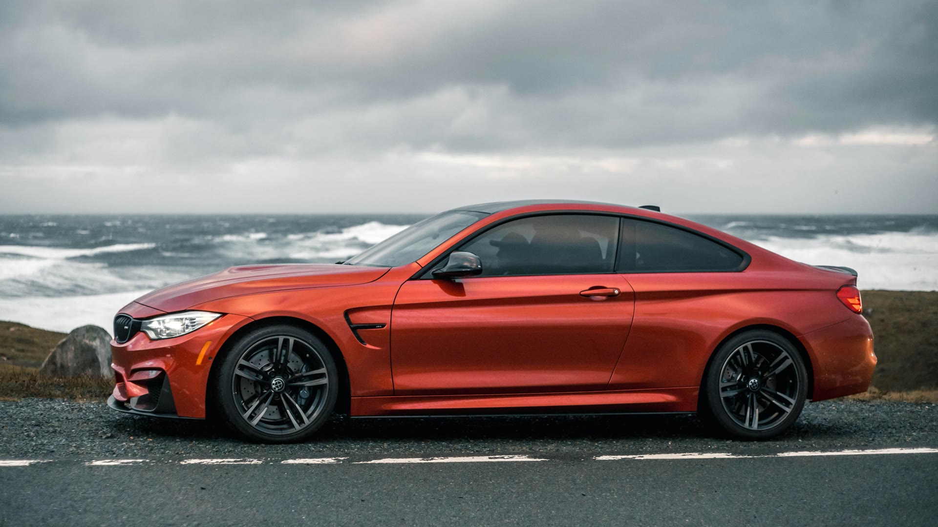 Car tinting prices Perth: red coupe with tinted windows under heavy cloud
