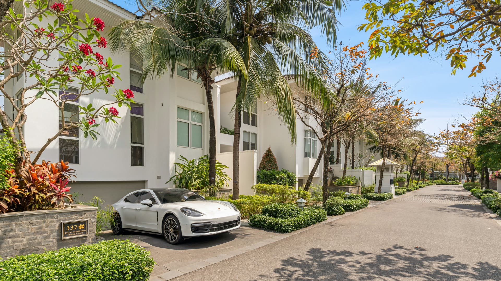 Car window tinting Guildford: a white luxury car parked outside a modern house