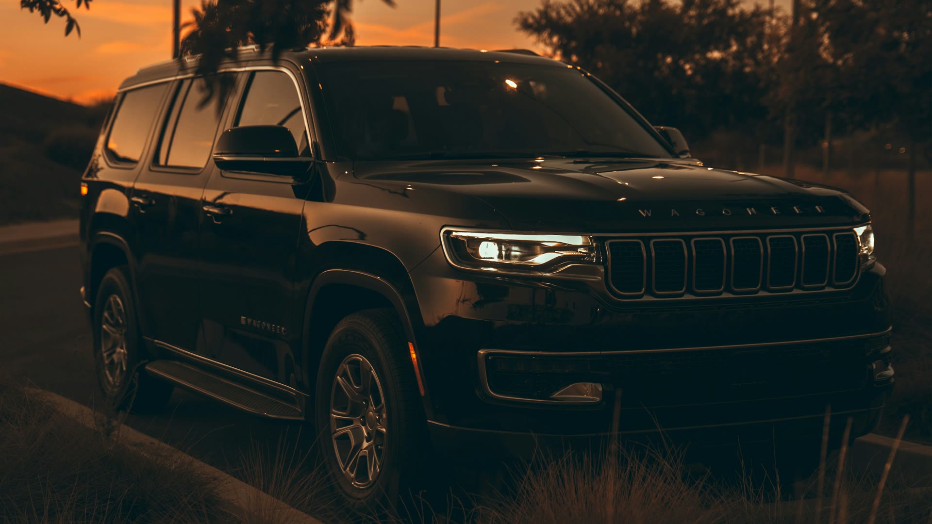 Car window tinting for privacy and security: black SUV with dark windows at sunset