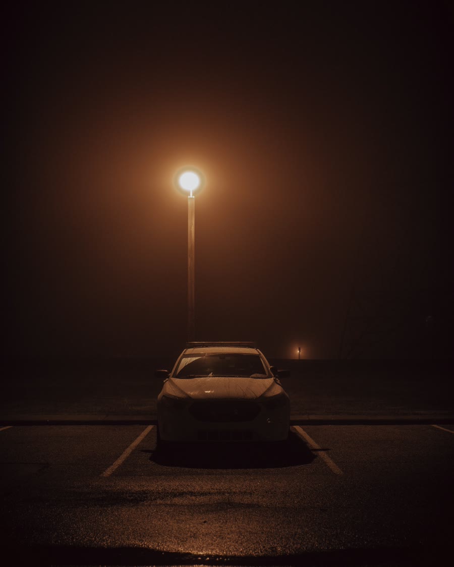 Window tinting and security: a car parked alone under a streetlight at night