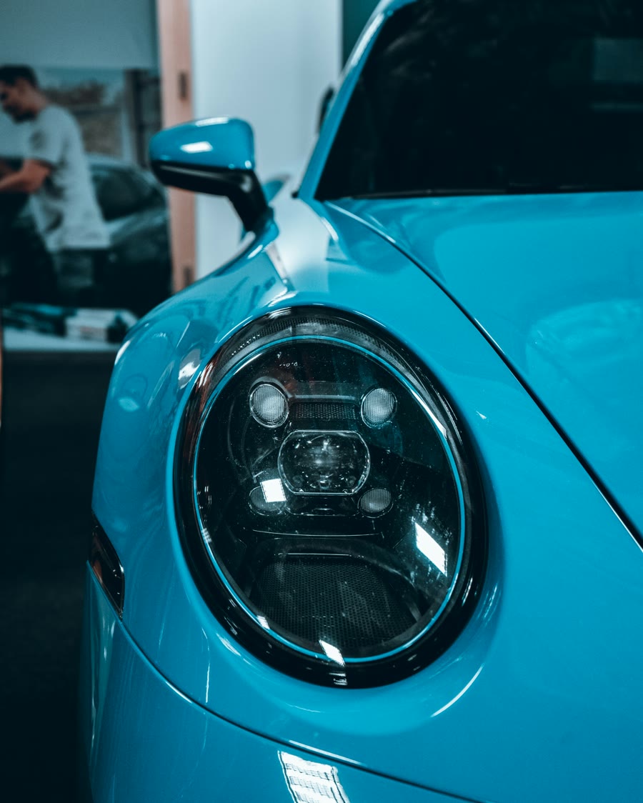 Ceramic coating detail: round headlight set into glossy light blue paint