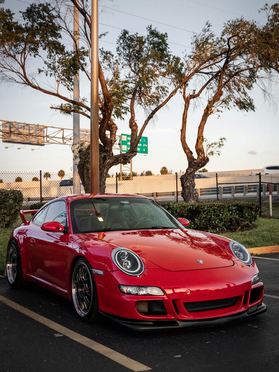 Carbon tinted side and rear windows on a red sports car in late afternoon sun